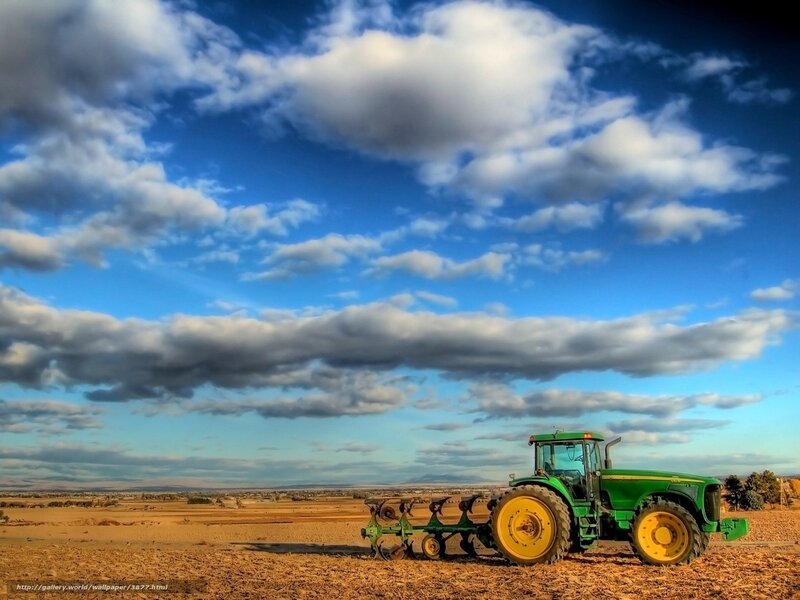 Tractor in a field under cloudy sky