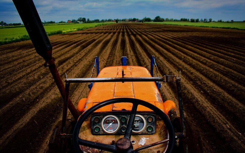 Tractor in Plowed Field — Orange