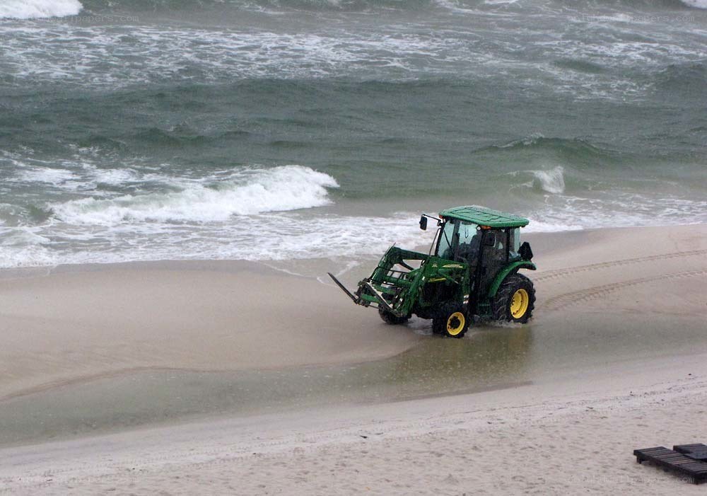 Tractor on a beach near waves