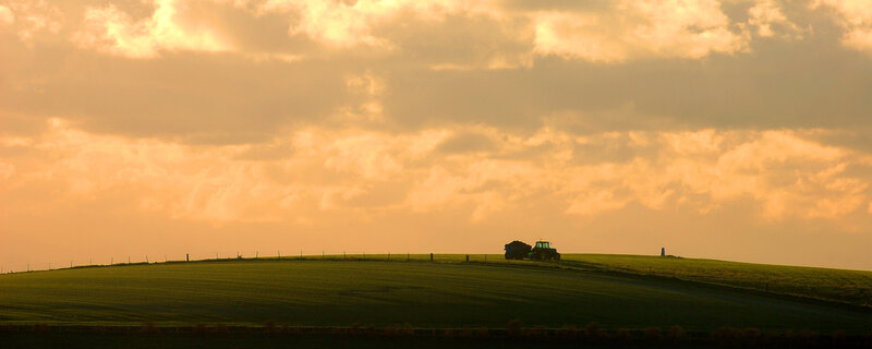 Tractor on a hill at sunset