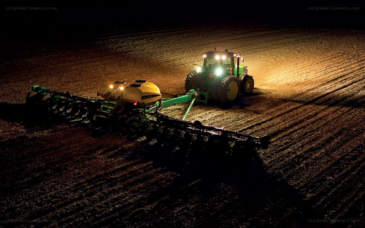 Tractor seeding field at night