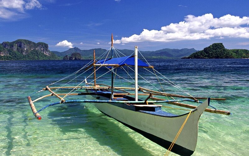 Traditional Boat in Clear Water — Blue, Serene, Afternoon, Photograph, Mountains, Blue Sky