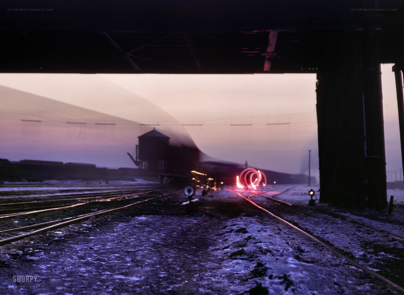 Train at dusk under a bridge