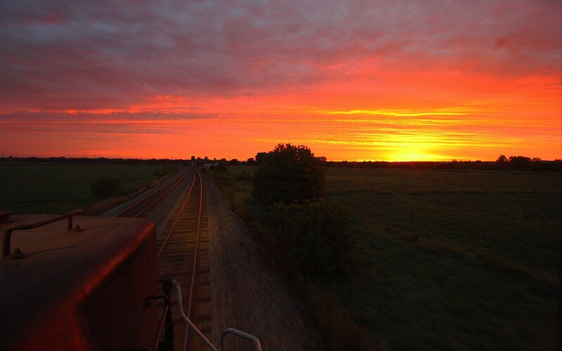 Train at sunset over fields