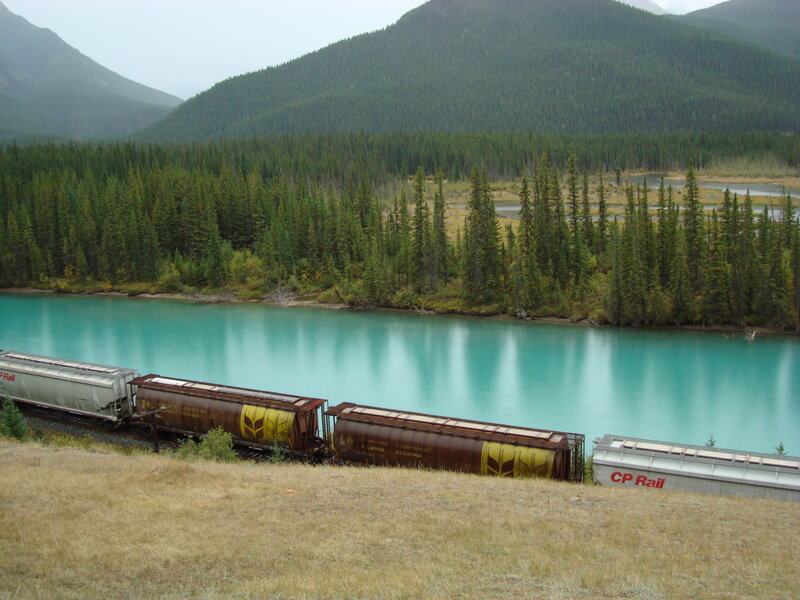 Train beside turquoise river