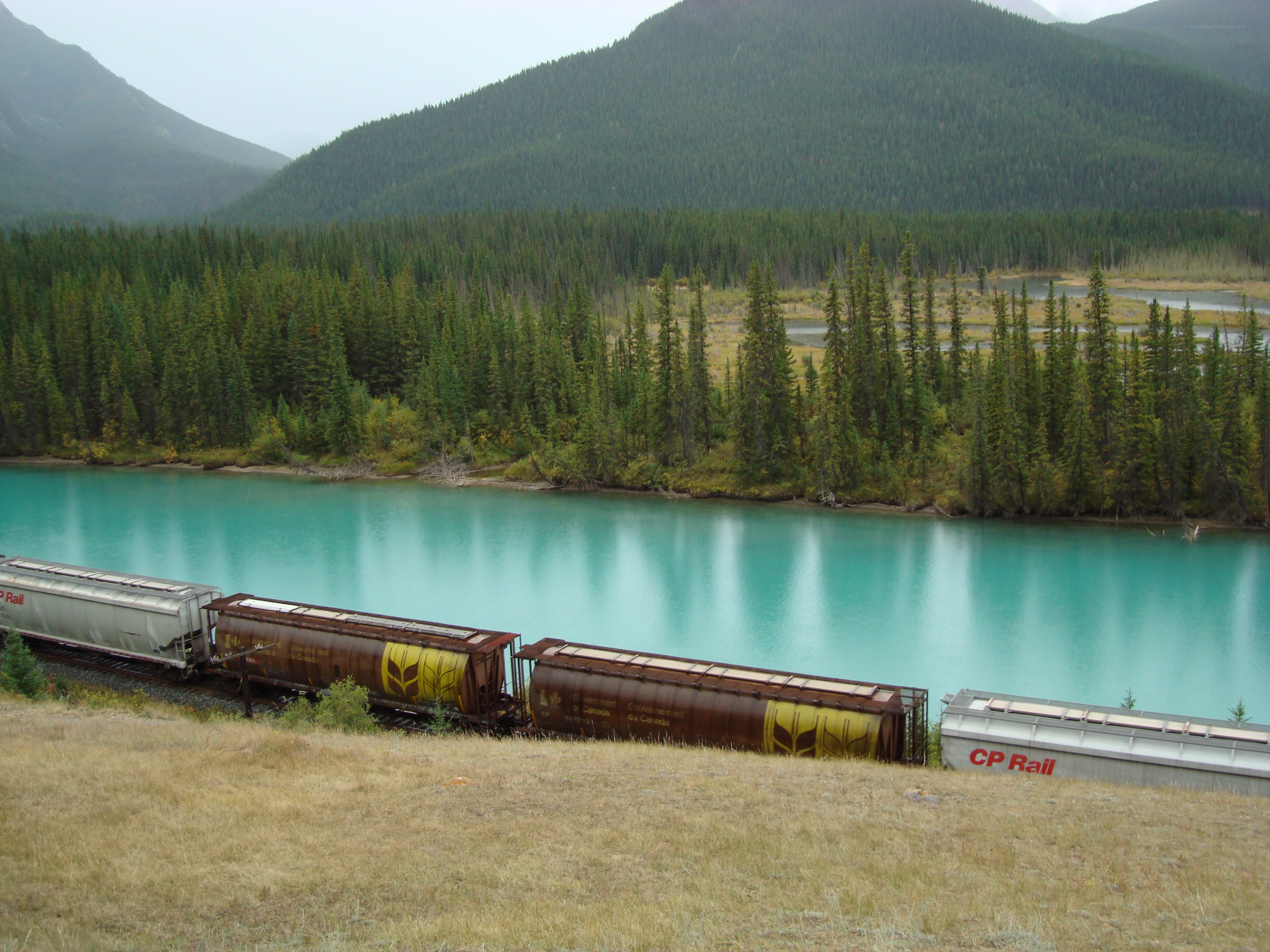 Train beside turquoise river