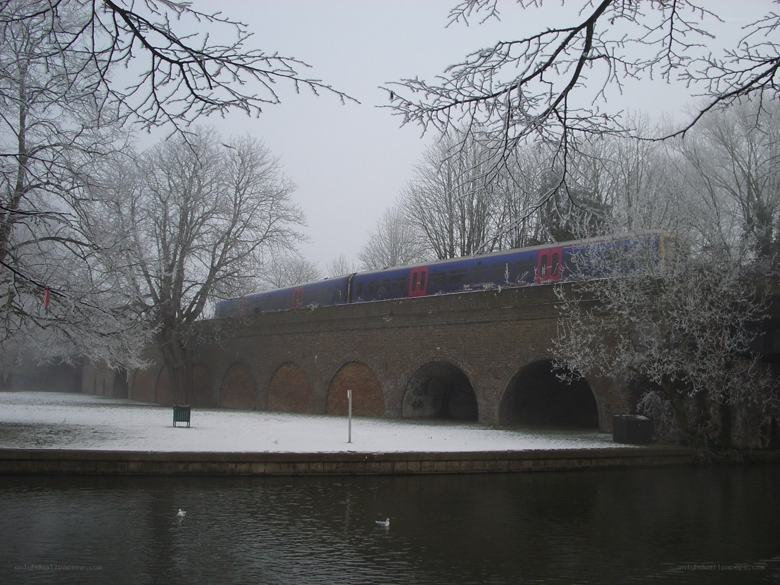 Train crossing a snowy bridge