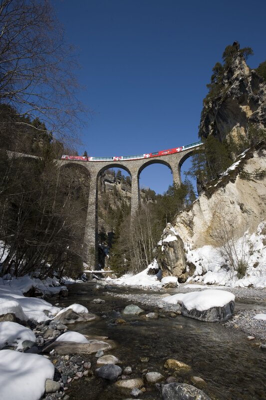 Train crossing a stone viaduct
