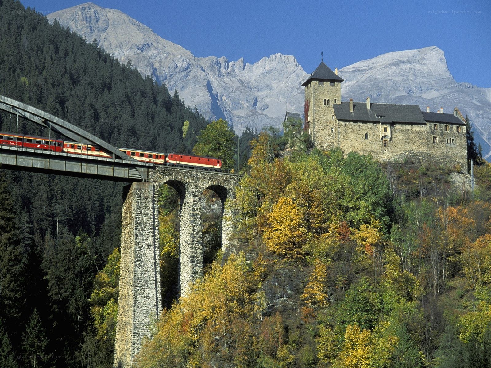 Train crossing bridge near castle