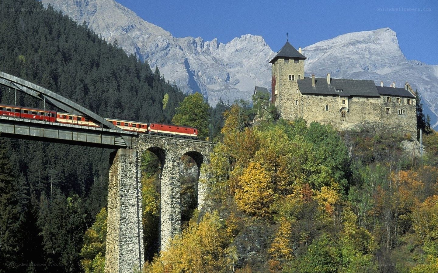 Train crossing bridge near castle