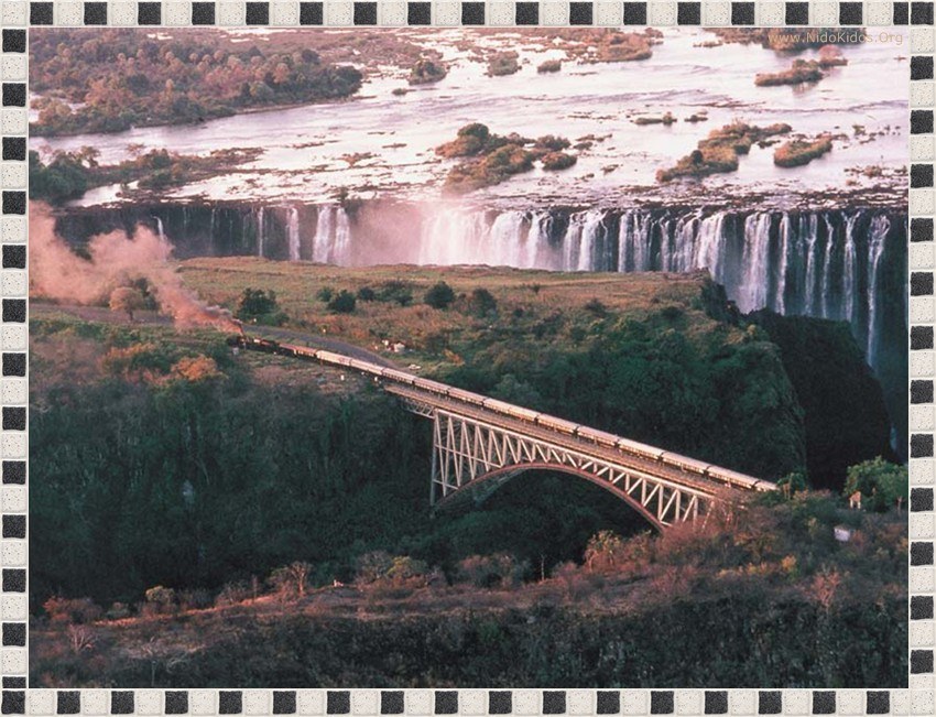 train crossing bridge near waterfall