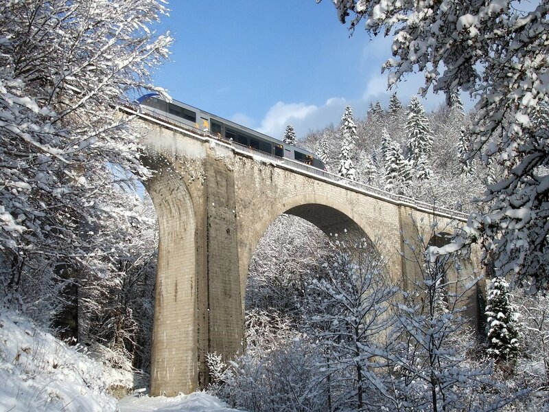 Train crossing snowy bridge