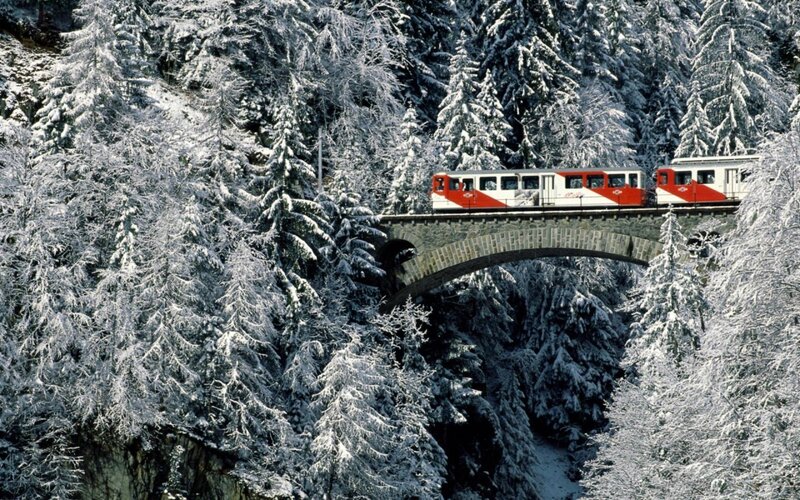 Train crossing snowy bridge