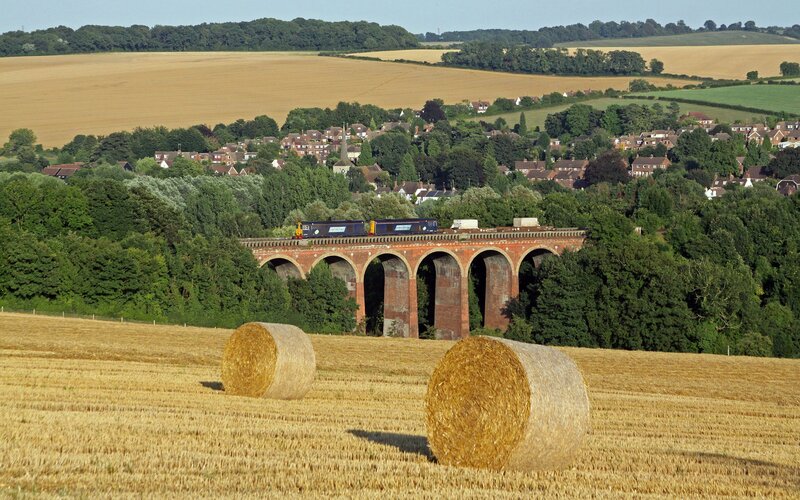 Train crossing viaduct in countryside