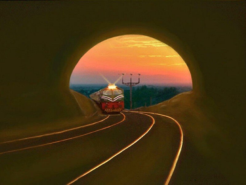 Train emerging from tunnel at sunset