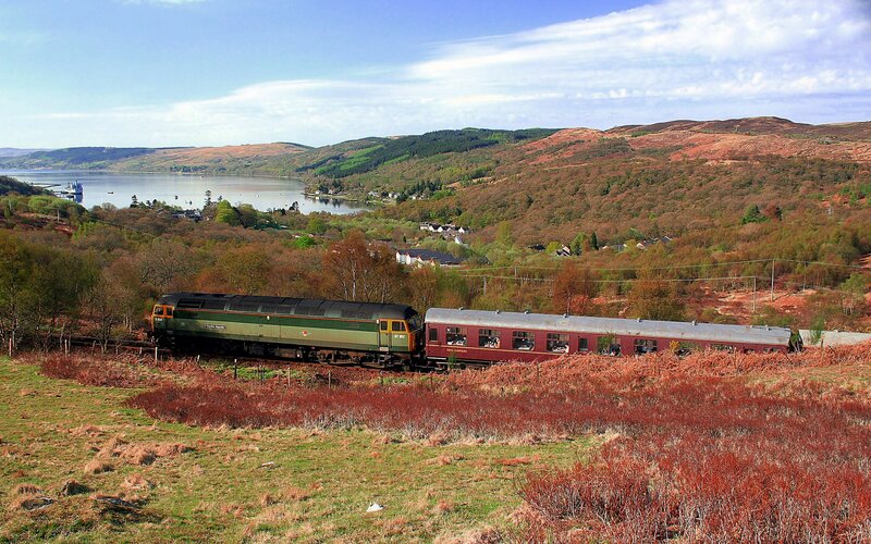 Train near a lake in the hills