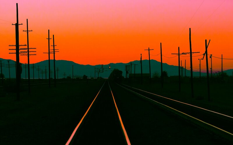 Train on Tracks at Sunset — Orange