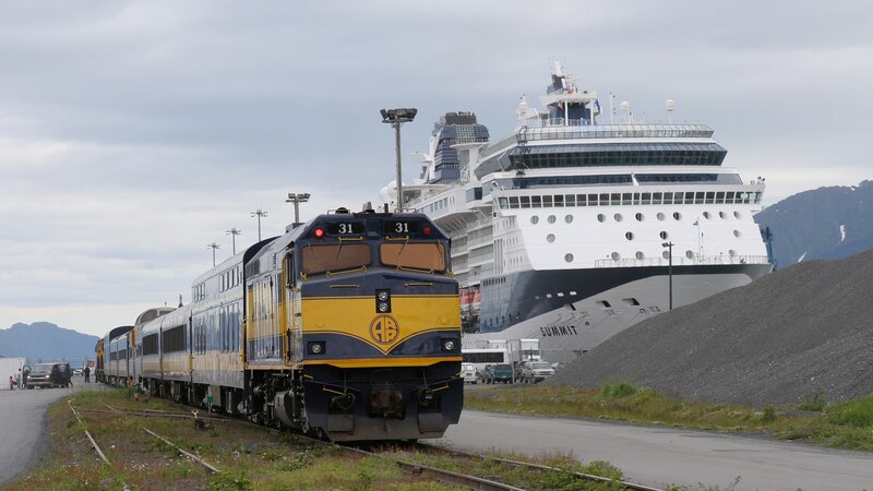 Train passing cruise ship in port