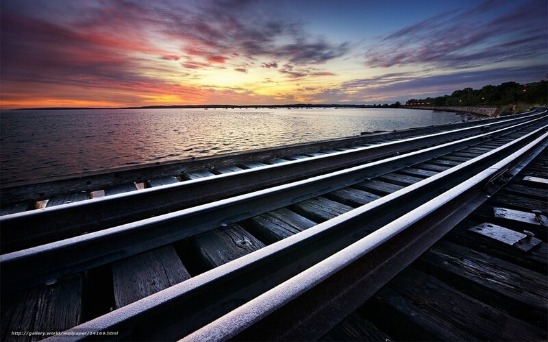 Train tracks at sunset by the water