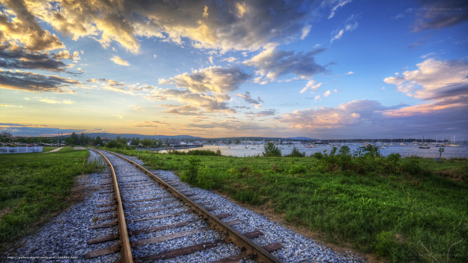 Train tracks by the water at sunset