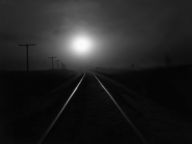 Train tracks in fog at night