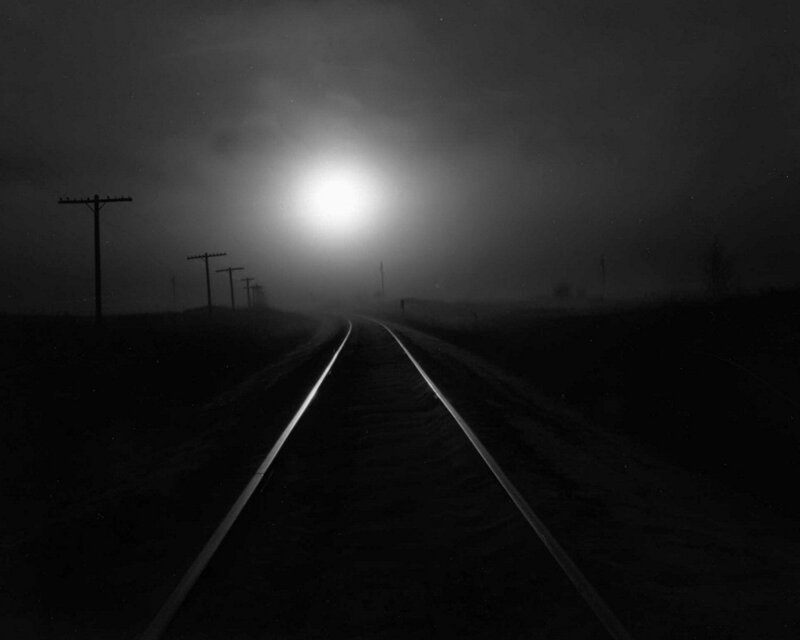 Train tracks in fog at night