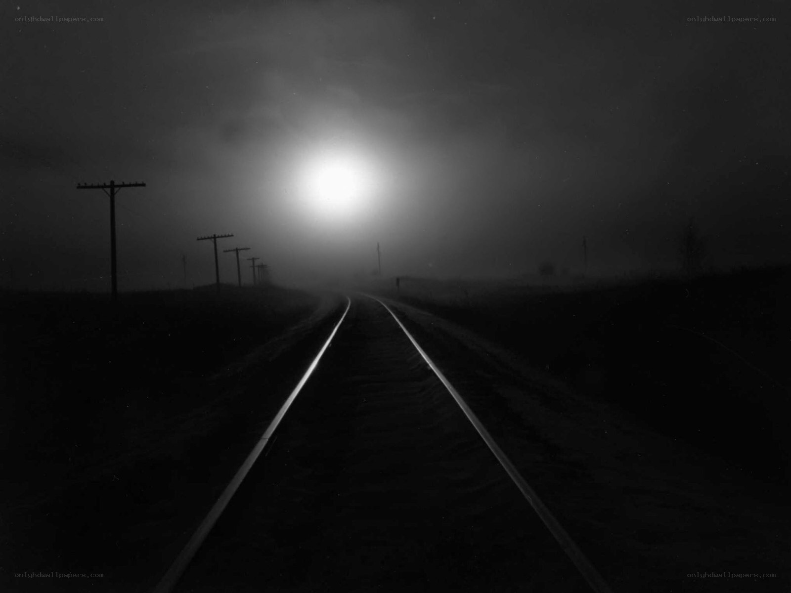 Train tracks in fog at night