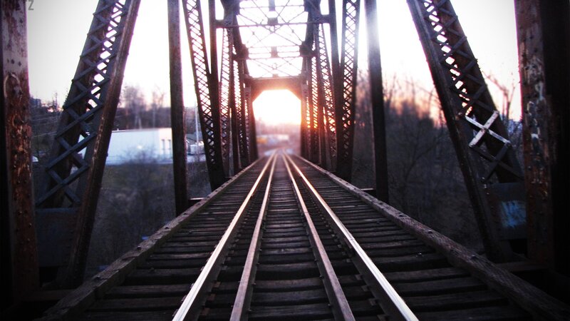 Train tracks on a bridge at sunset