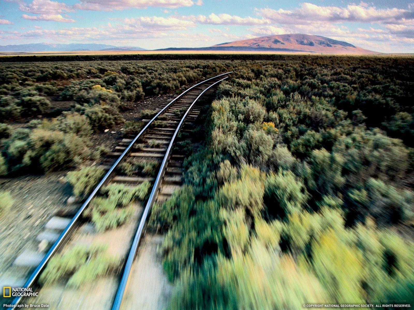 Train tracks through desert landscape