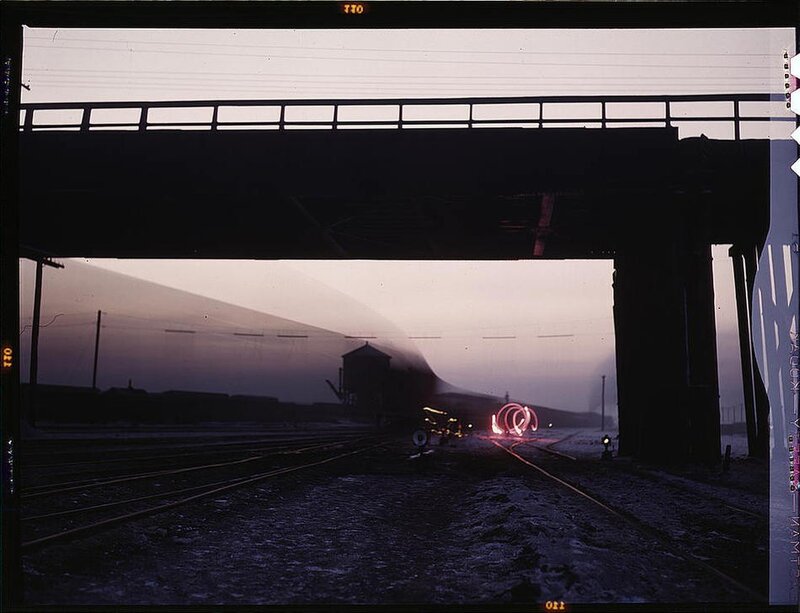 Train under a bridge at dusk