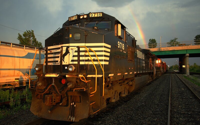 Train with rainbow in sky