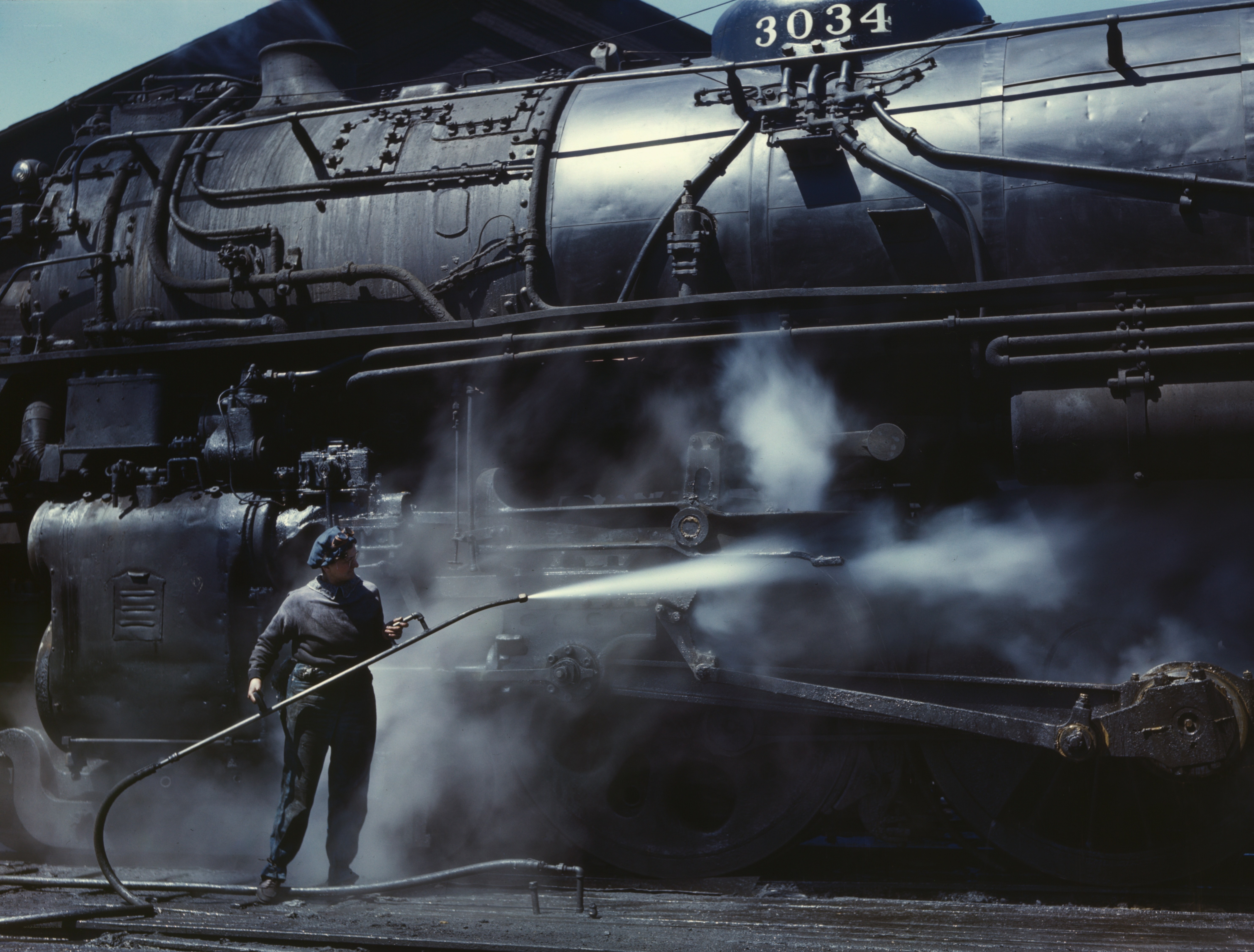 Train worker cleaning locomotive