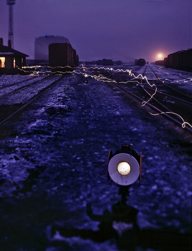 Train yard at dusk with light trails