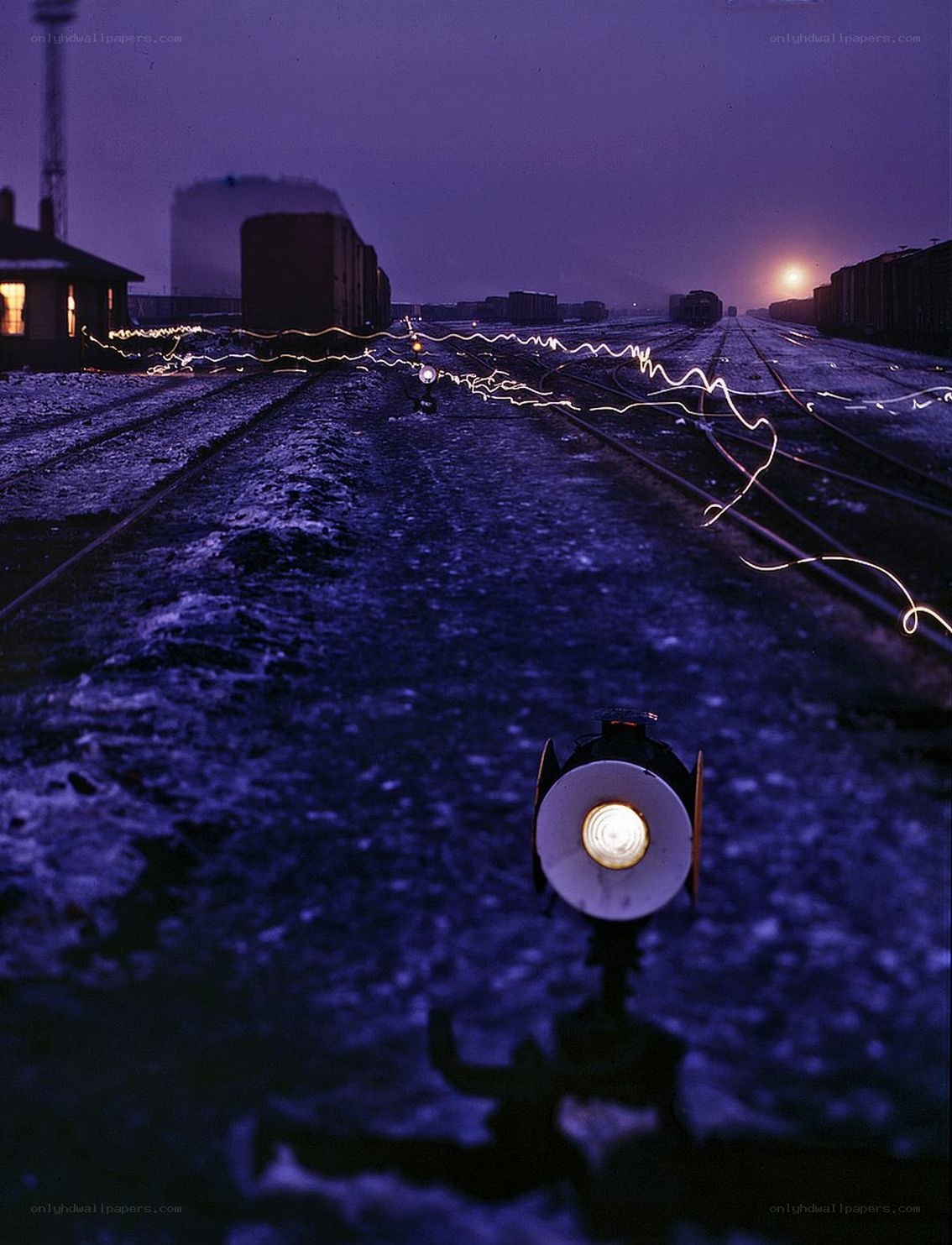 Train yard at dusk with light trails