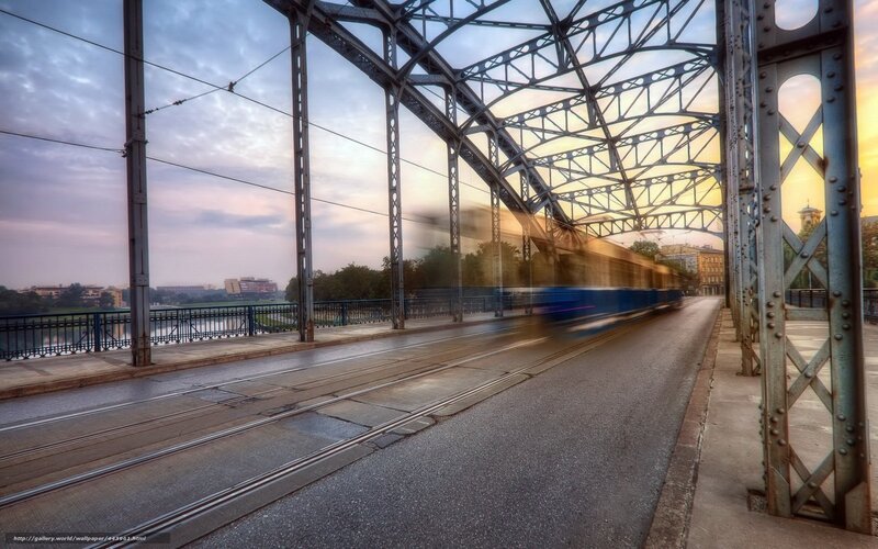 Tram crossing bridge at sunset