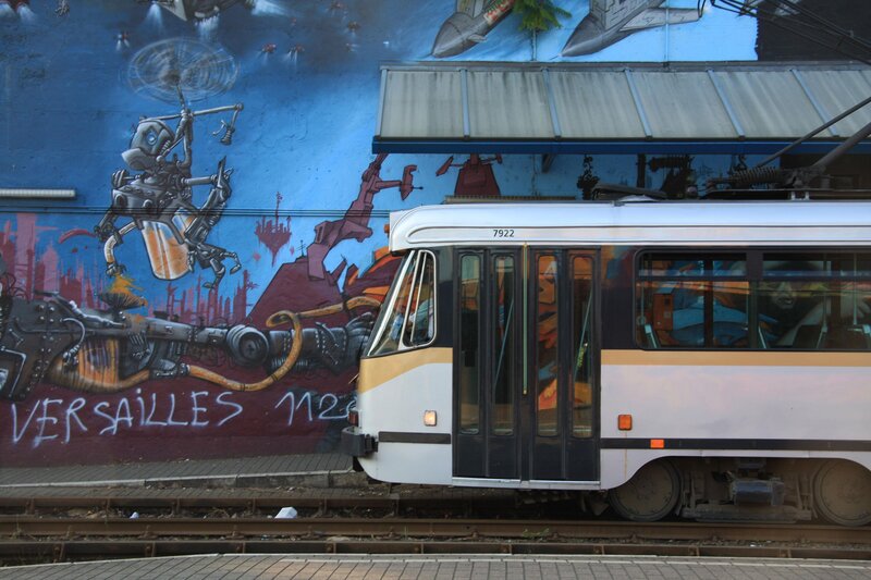 Tram passing graffiti wall