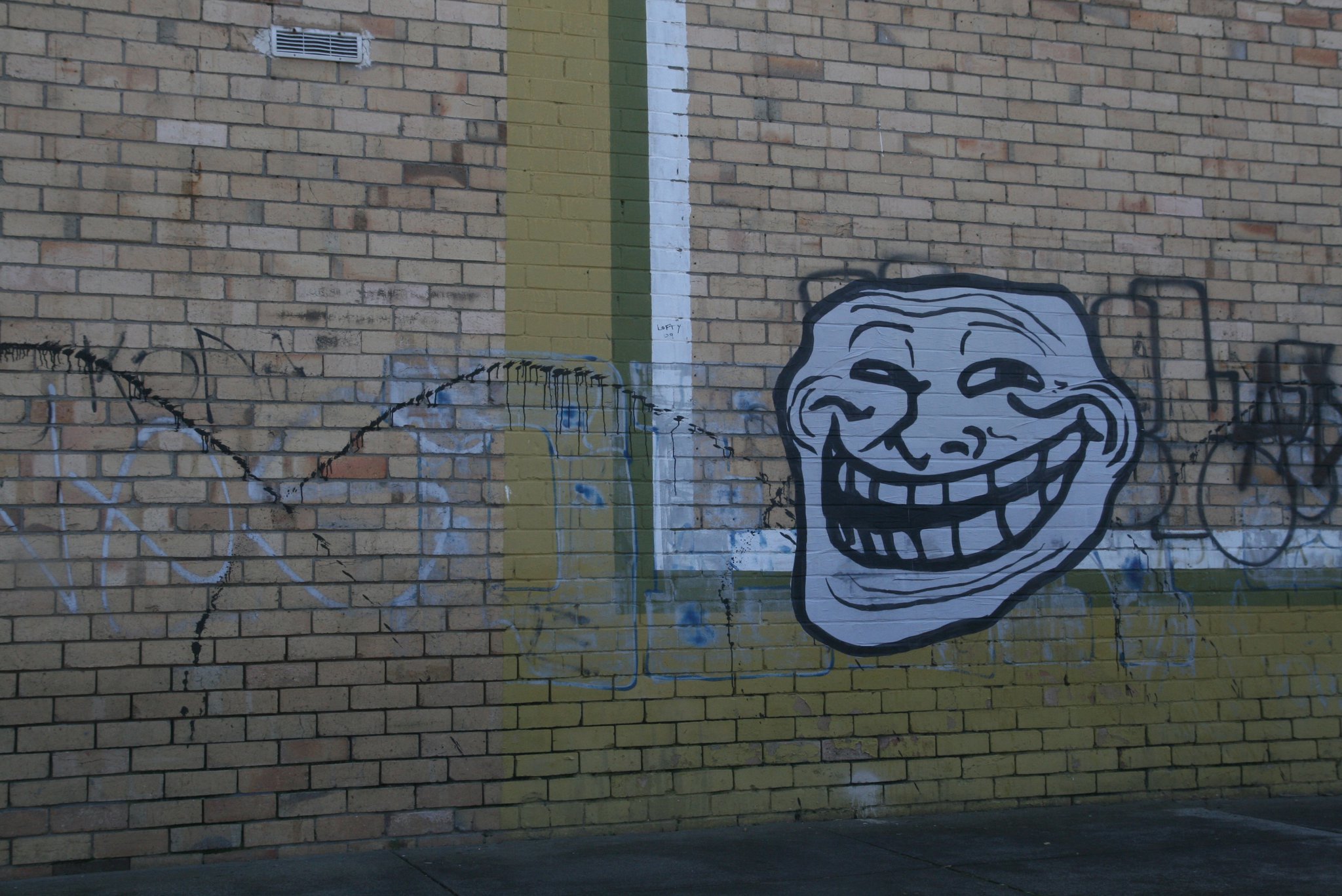 Troll Face graffiti on brick wall