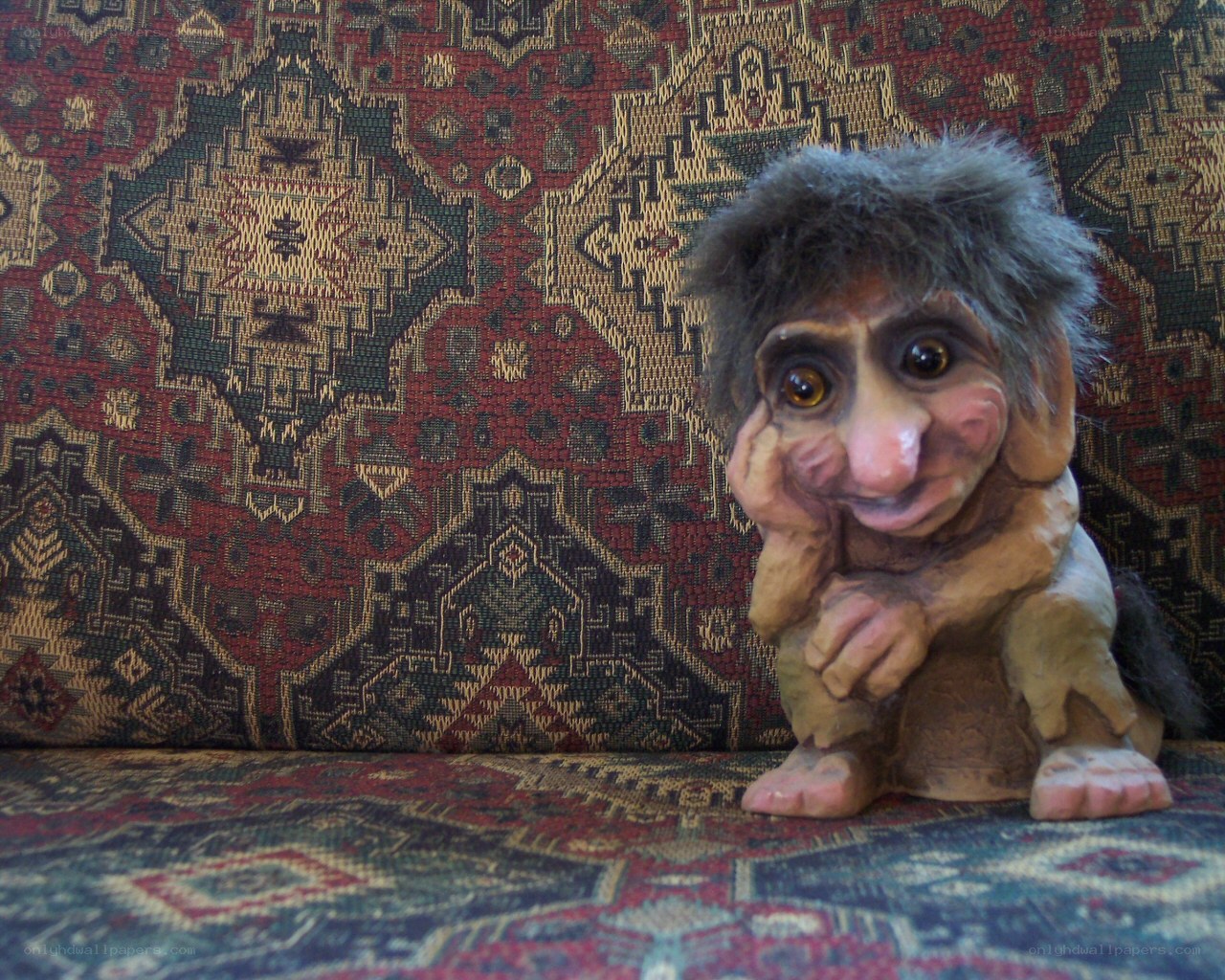 troll figurine on patterned couch