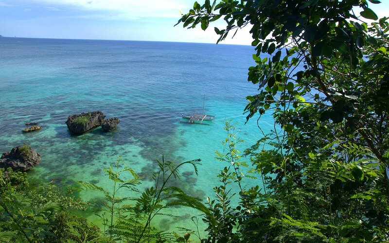 tropical bay with boat and rocks