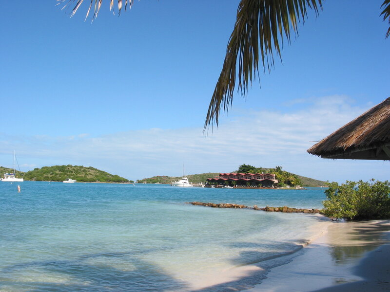 tropical beach with boats and resort