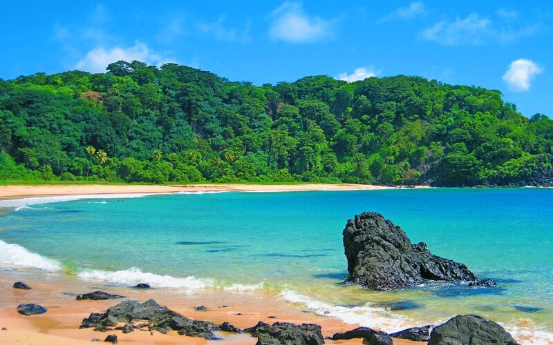 tropical beach with lush green hills