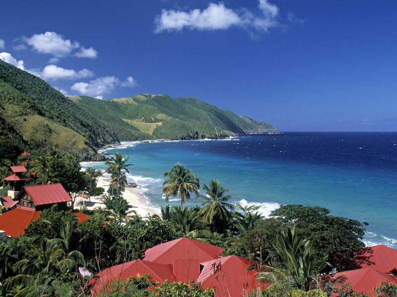 tropical beach with red-roofed buildings