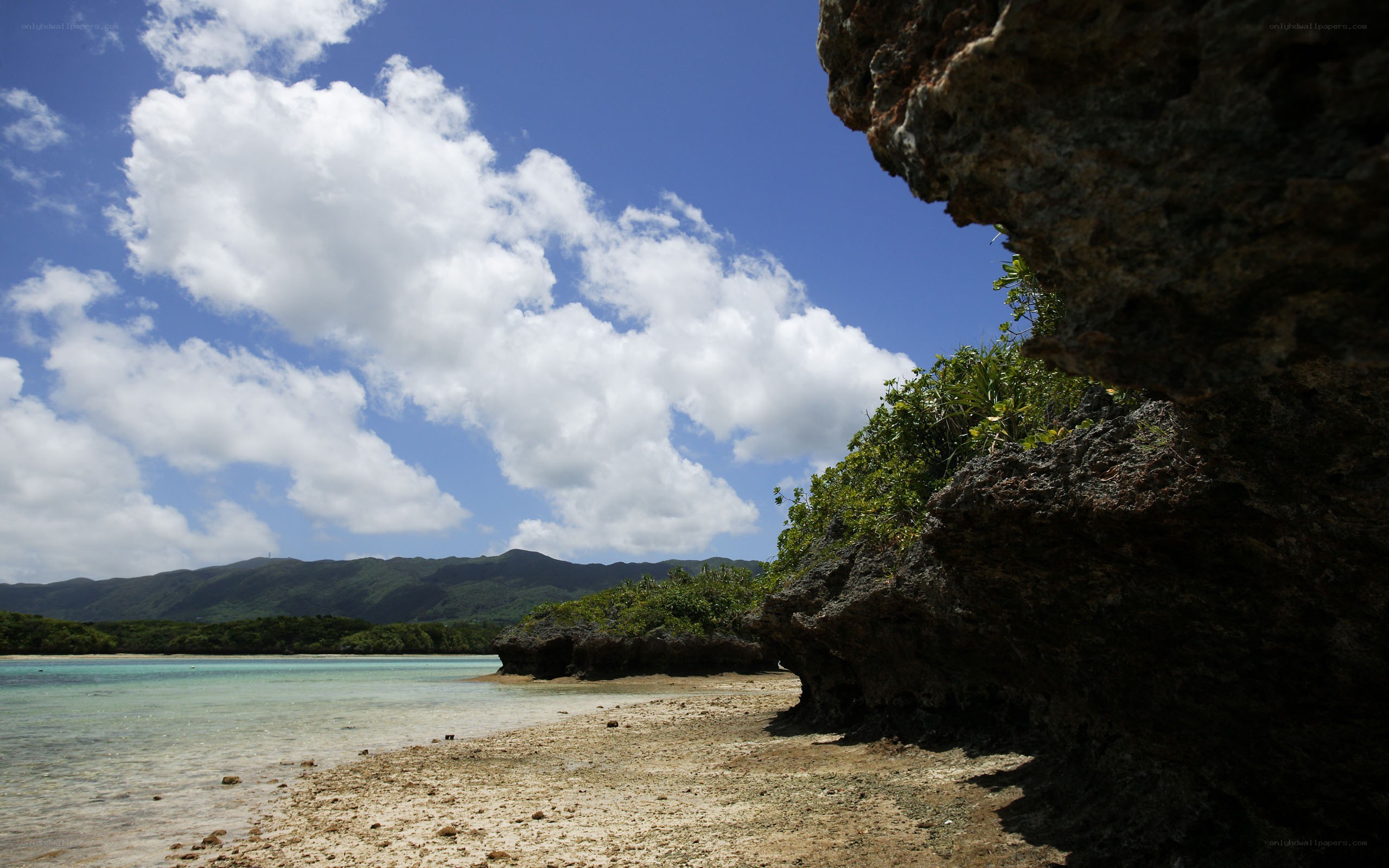 tropical beach with rocky overhang
