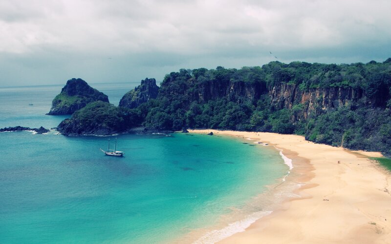 tropical beach with sailboat