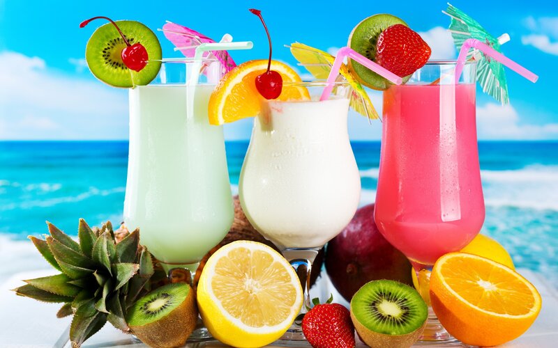 Tropical Drinks on Beach — Blue, Relaxed, Afternoon, Photograph, Fruit, Straws, Umbrellas