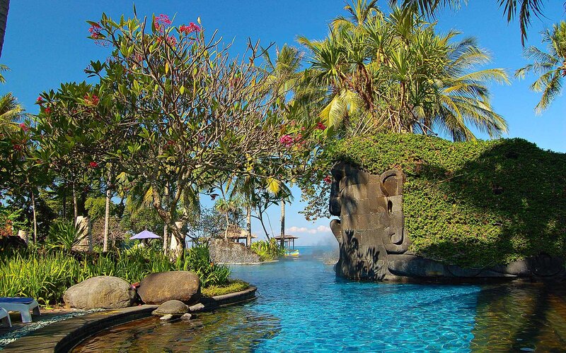 tropical resort pool with stone sculpture