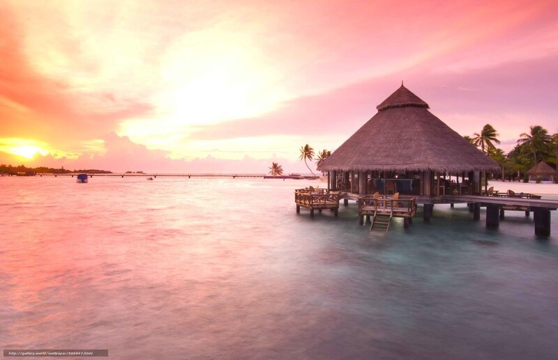 Tropical sunset over water bungalow