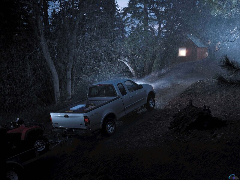 Truck in rainy forest at night