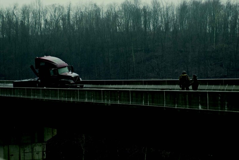 Truck on a bridge with two people