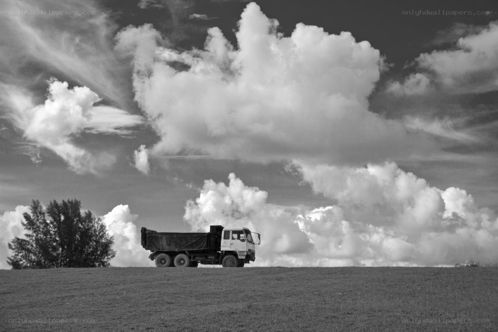 Truck on a hill under clouds